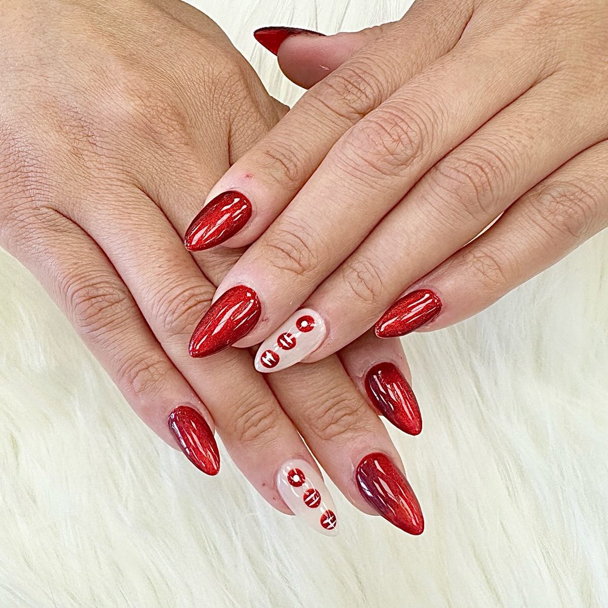 Cherry red glitter almond nails with polka-dot accent